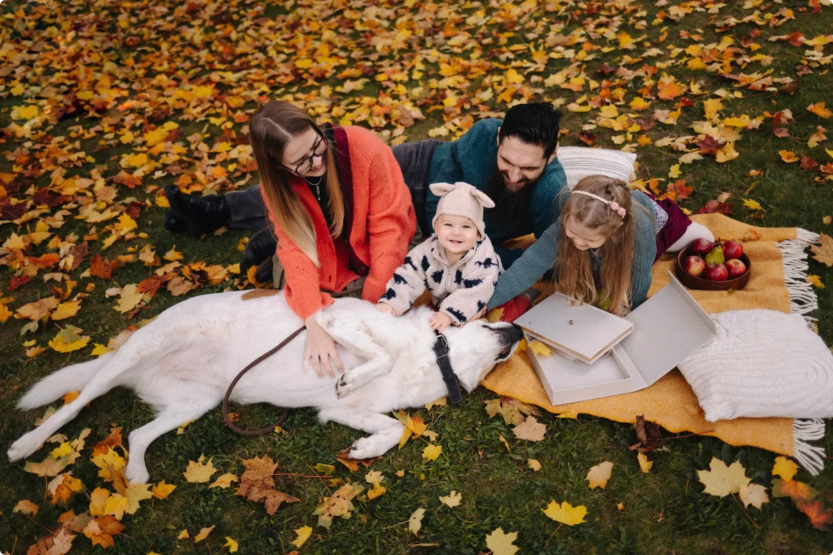 Die Gründerfamilie von Mriella: Lina und Alexander mit ihren Kindern und Hund beim gemeinsamen Picknick im Herbstlaub.