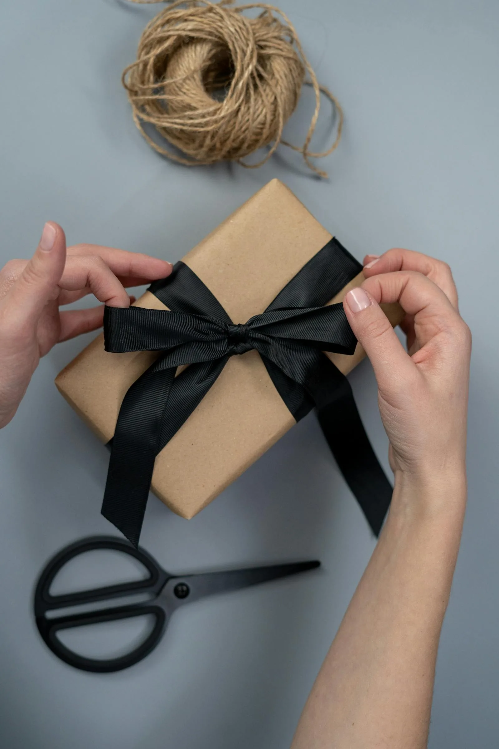 Schlichte braune Geschenkbox aus Kraftpapier mit schwarzem Band als Taufgeschenk
