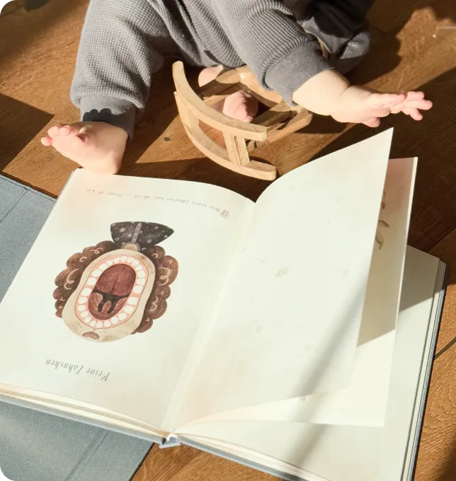 Liebevolle Illustrationen und dezente Ausfüllhilfen auf den Innenseiten des Mriella Babyalbums.