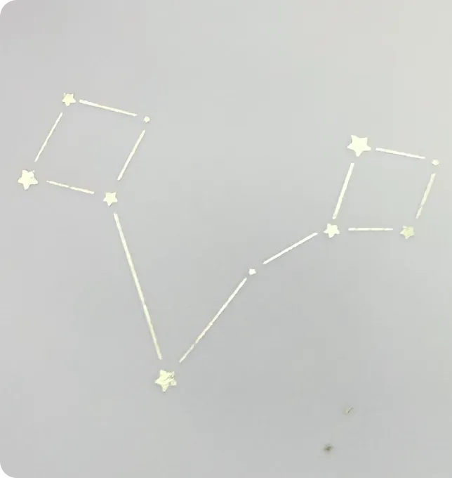 Goldene Heißfolienprägung eines Sternzeichens auf der ersten Vellum Seite des Mriella Piccolo Babyalbums.